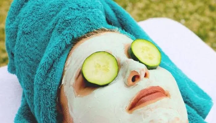 A woman relaxing at home with cooling cucumber slices over her eyes to reduce under-eye puffiness.