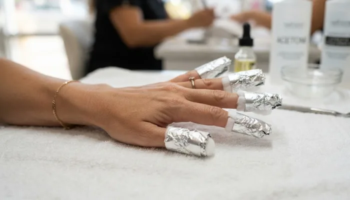 Fingers wrapped in foil and cotton for acetone nail extension soaking Fingers wrapped in foil and cotton for acetone nail extension soaking