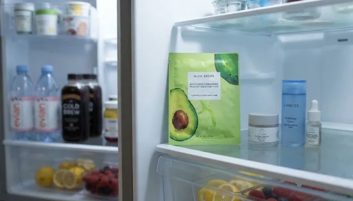 A hydrating face sheet mask being stored inside a refrigerator for a cooling skincare routine A hydrating face sheet mask being stored inside a refrigerator for a cooling skincare routine